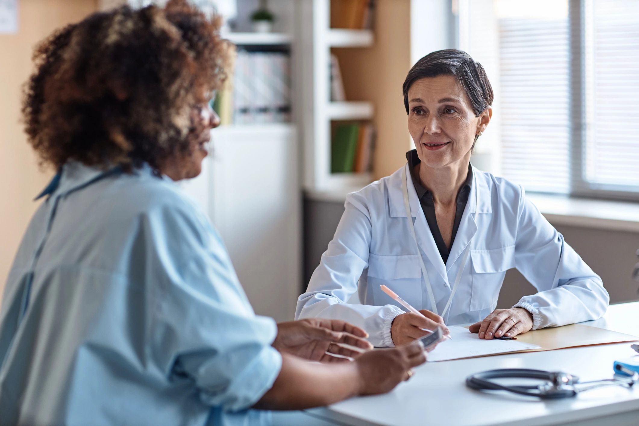 Psychiatrist speaking with an adult patient in a supportive clinical setting